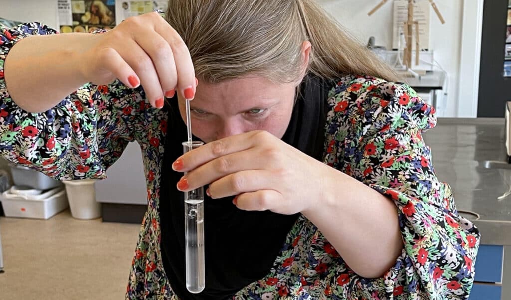 Lærer rører i reagensglas på et kursus for naturfagslærere