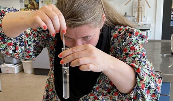 Lærer rører i reagensglas på et kursus for naturfagslærere